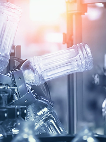 Plastic PET recycled bottles preparing for filling with drink. Water and juice bottling factory in blue color.