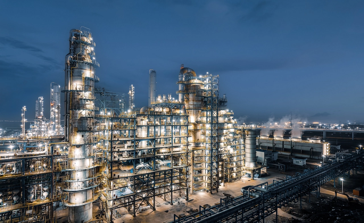 Panoramic view of oil refinery and petrochemical plant with lights at night.
