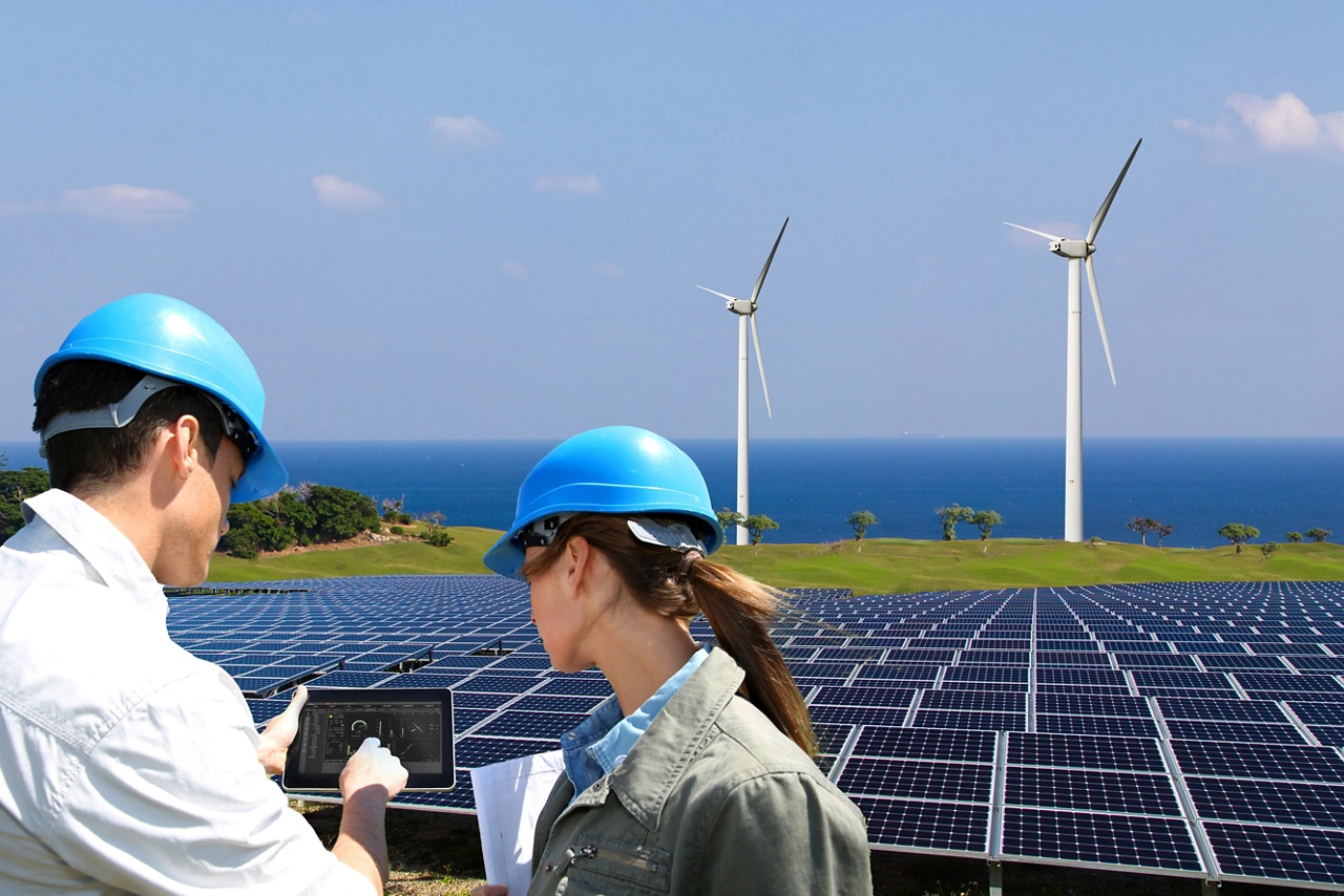 Wind turbines in the background of a solar panel field