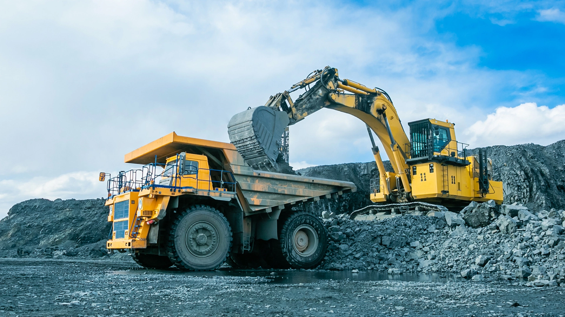 Work of trucks and the excavator in an open pit on gold mining, soft focus